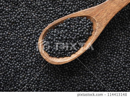 Wooden spoon of black organic healthy lentils grain seed. 114413148