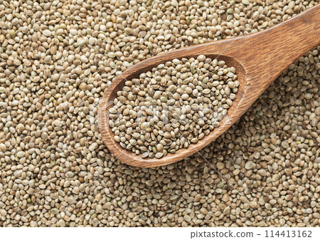 Green raw healthy organic hemp food seeds on wooden spoon in kitchen. 114413162