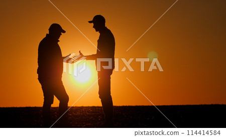 Firm handshake between two men at sunset 114414584