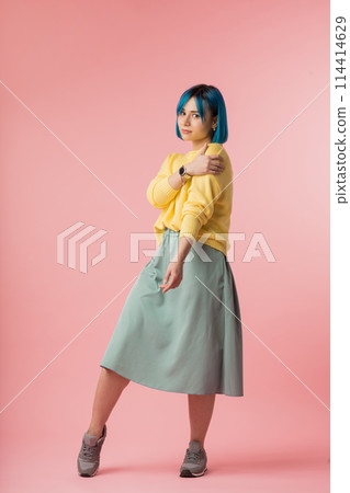 modest girl holding her shoulder and looking at the camera 114414629