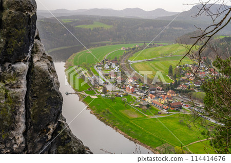 Overlooking the gentle curve of the Elbe River, surrounded by the lush greenery of Saxon Switzerland National Park. Germany 114414676