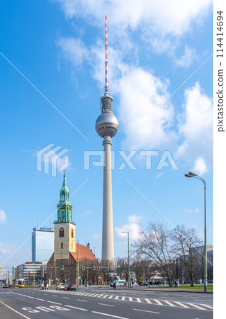 The Berlin TV Tower looms over the historic Saint Mary Church under a clear blue sky. The Berlin TV Tower looms over the historic Saint Mary Church under a clear blue sky. 114414694