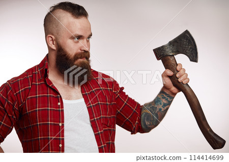 bearded male holding axe and posing in studio bearded male holding axe and posing in studio 114414699