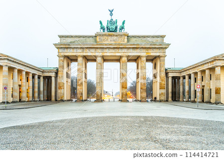The Brandenburg Gate stands majestically during dawn, its quiet presence dominating an empty Pariser Platz in Berlin. 114414721