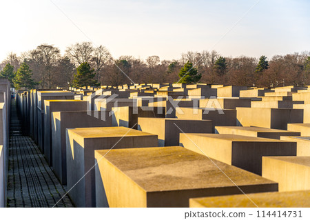 Concrete slabs arranged in a grid form the Holocaust Memorial under the clear sky in Berlin. Germany Concrete slabs arranged in a grid form the Holocaust Memorial under the clear sky in Berlin. Germany 114414731