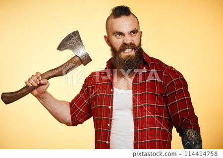 agressive lumberjack. bearded man swinging with axe 114414758