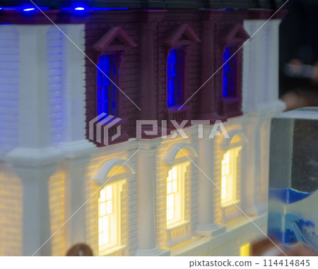 Prototype printed on 3D printer brick building with columns and glowing windows. Model of building with white and brown color, windows with light shining, created by 3D printer from molten plastic Prototype printed on 3D printer brick building with columns and glowing windows. Model of building with white and brown color, windows with light shining, created by 3D printer from molten plastic 114414845