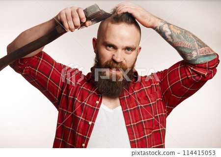 bearded man shaving with an axe on black background 114415053