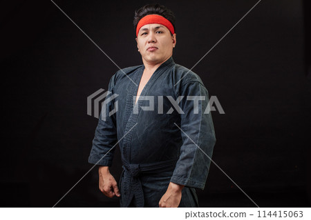 Fat karate fighter posing to the camera. boss in karate Fat karate fighter posing to the camera. boss in karate 114415063