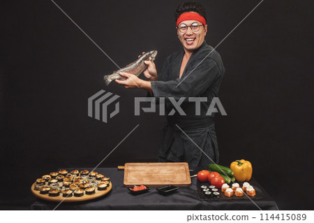 attractive smilingman holding a big fish and posing to the camera attractive smilingman holding a big fish and posing to the camera 114415089