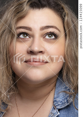 Portrait of a beautiful fat woman close-up on a gray background. Portrait of a beautiful fat woman close-up on a gray background. 114415099