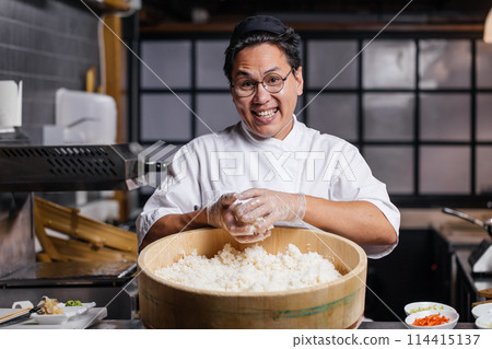 positive guy in uniform holding rice and posing to the camera 114415137