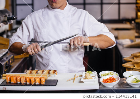 Chinese chef posing with knives 114415141