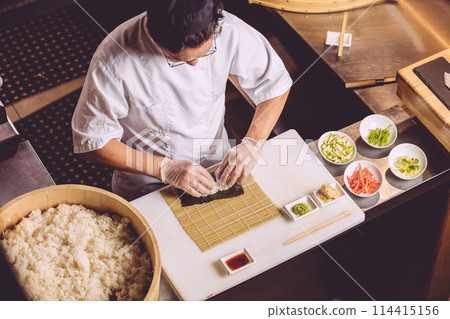 close up photo. top view awesome guy putting rice for roll 114415156