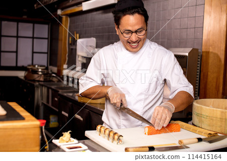 happy handsome Asian man cutting sushi 114415164
