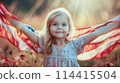 Portrait of a cute blonde girl holding a large American national flag behind her back. The concept of celebrating Independence Day in America on July 4th 114415504