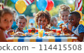 Small light-skinned and African-American children sit at the dining table and eat delicious burgers against the background of nature. The concept of celebrating Independence Day in America on July 4th 114415508