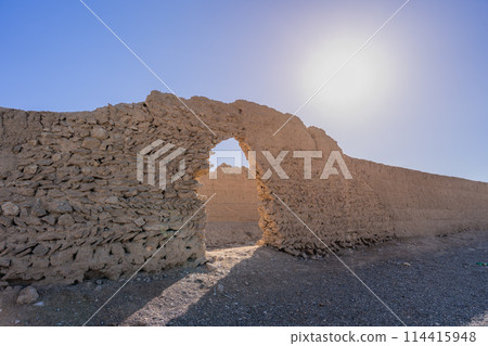 The sun shines brightly on the ancient ice storage towers in Yazd, Iran. 114415948