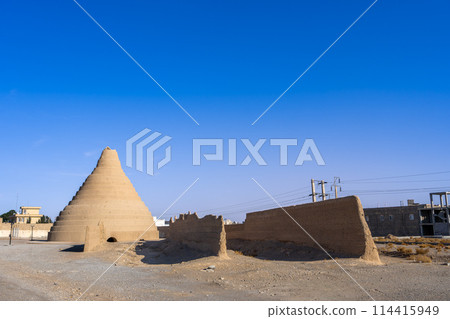 The sun shines brightly on the ancient ice storage towers in Yazd, Iran. The sun shines brightly on the ancient ice storage towers in Yazd, Iran. 114415949