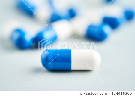 Blue and white capsules on a blue background. Blue and white capsules on a blue background. 114416300