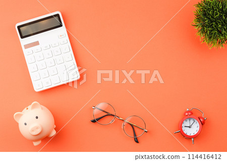 Piggy bank with calculators office desk top view. 114416412