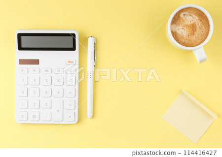 White calculator on yellow background White calculator on yellow background 114416427