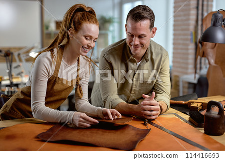 happy craftmen learning to work with leather in the workshop 114416693