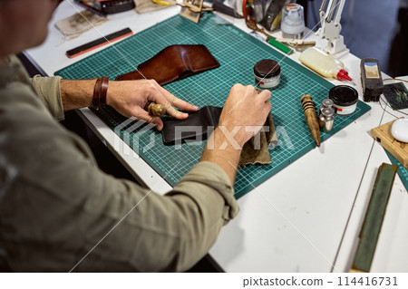 professional artisan makes an old leather wallet look new 114416731