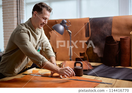 excited youn man concentrated on measuring material excited youn man concentrated on measuring material 114416770