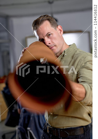 young man using leather roll as a grenade launcher. 114416812