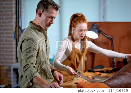 young handsome man choosing leather, tools for work at workplace young handsome man choosing leather, tools for work at workplace 114416839