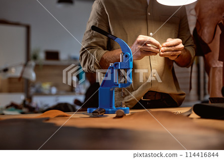 young skilled artisan decorating designing belt at workplace young skilled artisan decorating designing belt at workplace 114416844