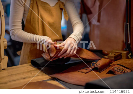 young skilled artisan restoes old bad leather 114416921