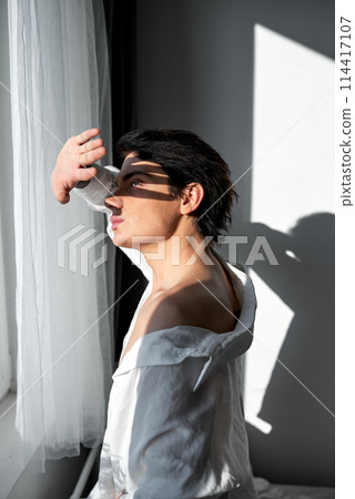 Young man closing his eyes under the sun Young man closing his eyes under the sun 114417107