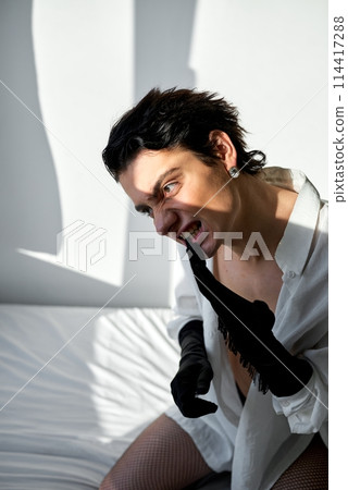 angry brunette actor in white shirt biting his gloves, taking off them 114417288