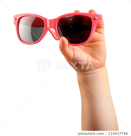 Child's hand holding sunglasses isolated on a white or transparent background. Close-up of pink glasses in hand. Rest, holidays, sun protection. Vacation and travel concept. 114417746