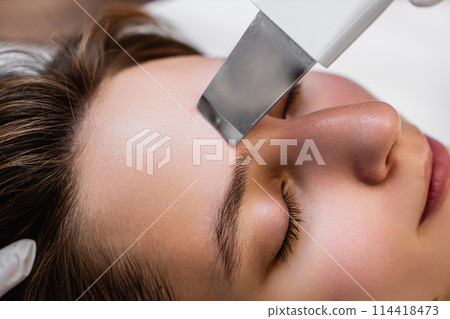 Ultrasonic cleaning of the face. Skin peeling. 114418473