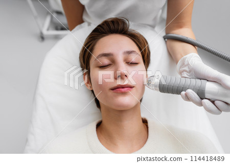 A cosmetologist performs hydropiling in a beauty salon. Skin care. A cosmetologist performs hydropiling in a beauty salon. Skin care. 114418489