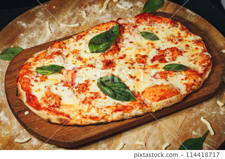 Handcrafted Heart-Shaped Margherita Pizza on Wooden Board, Garnished With Fresh Basil Leaves 114418717