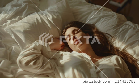 Woman Laying in Bed With White Sheets 114419793