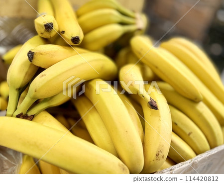 Ripe juicy yellow bananas close-up on a shelf in a supermarket. Close-up Ripe juicy yellow bananas close-up on a shelf in a supermarket. Close-up 114420812