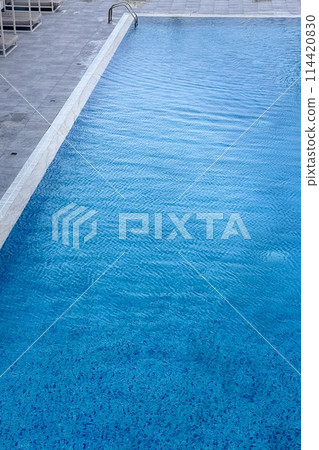 Clean beautiful outdoor pool in a prestigious hotel in a seaside resort. There is sea wave summer texture crystal with waves. Summer vacation concept is on inclusive 114420830