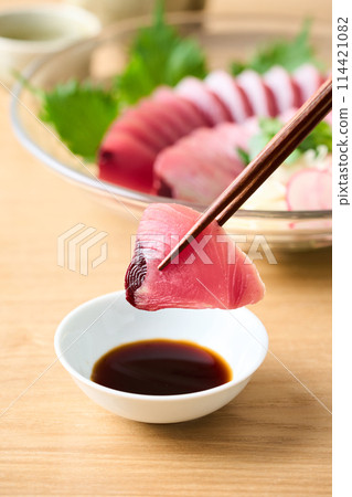 將鰹魚生魚片浸泡在醬油中 將鰹魚生魚片浸泡在醬油中 114421082