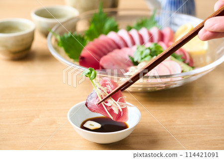 Marinating bonito sashimi in soy sauce 114421091