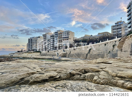 Rocky seashore with blue sea and sky at Sliema, Malta. Natural background Rocky seashore with blue sea and sky at Sliema, Malta. Natural background 114421631