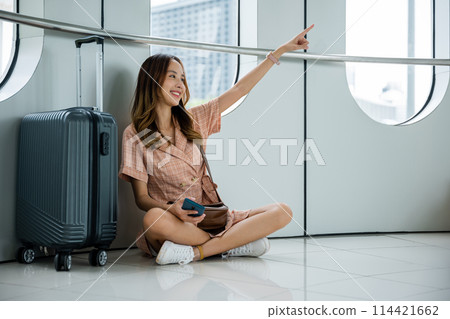 With her casual attire, barefoot on the carpeted floor, a focused brunette woman pointing towards an object, showing determination and motivation to achieve her goals. 114421662