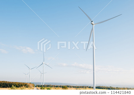 Nature meets technology, turbines on a mountain farm harness wind power for clean electricity. A modern windmill industry supporting sustainable development. Nature meets technology, turbines on a mountain farm harness wind power for clean electricity. A modern windmill industry supporting sustainable development. 114421840