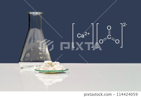 Calcium carbonate chip in chemical watch glass with molecular structure on white laboratory table. Side view 114424059