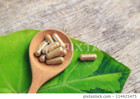 Healthy food medicine in capsules for health care eating with herb leaf on spoon 114425475
