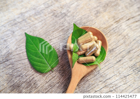 Healthy food medicine in capsules for health care eating with herb leaf on spoon 114425477
